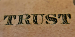 The word Trust tattooed on someones skin